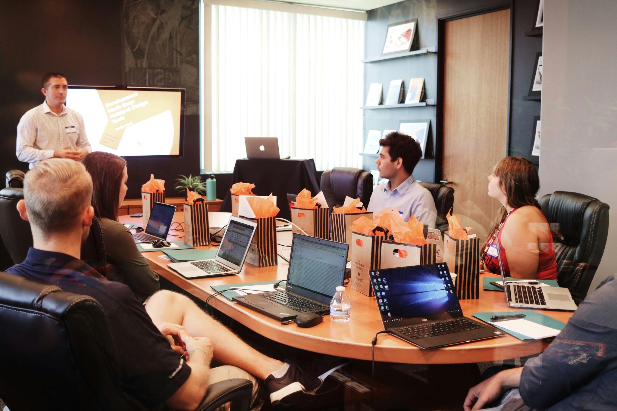 Equipo de trabajo en sala de juntas analizando estrategias de contratación con tecnología, ideal para entrevistas conductuales.