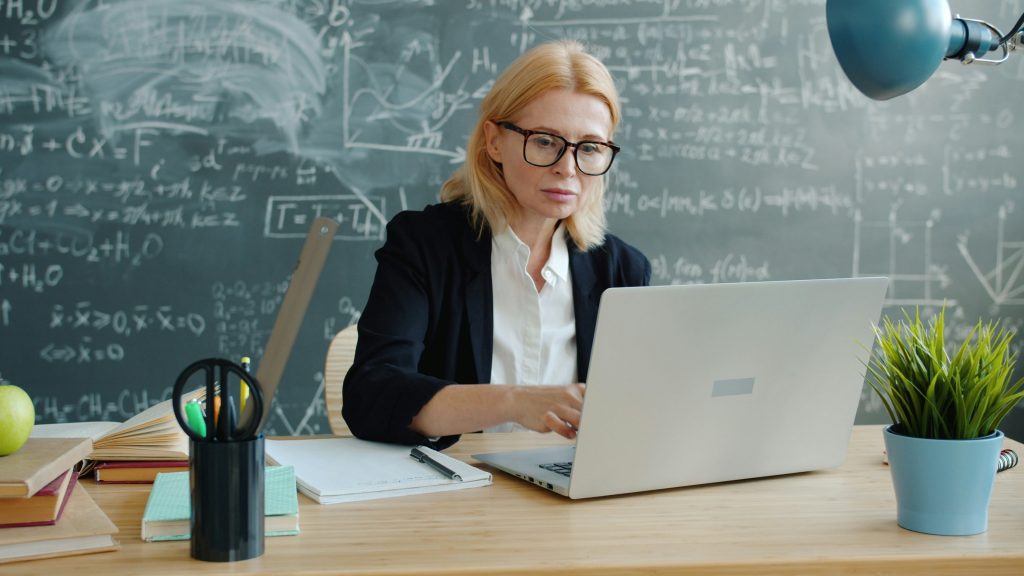 Reclutadora revisando reportes en laptop para interpretar resultados de examen psicométrico para empleo
