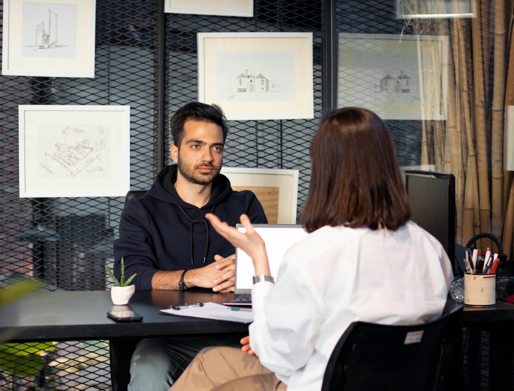 Reclutadora realizando entrevista presencial para definir qué preguntar en una entrevista de trabajo y evaluar competencias del candidato